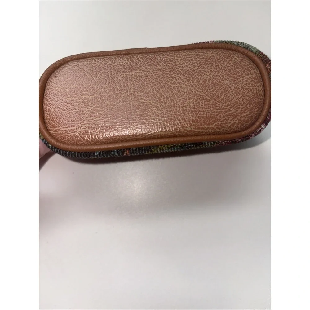 This vintage I Santi floral tapestry cosmetic bag features a brown leather trim